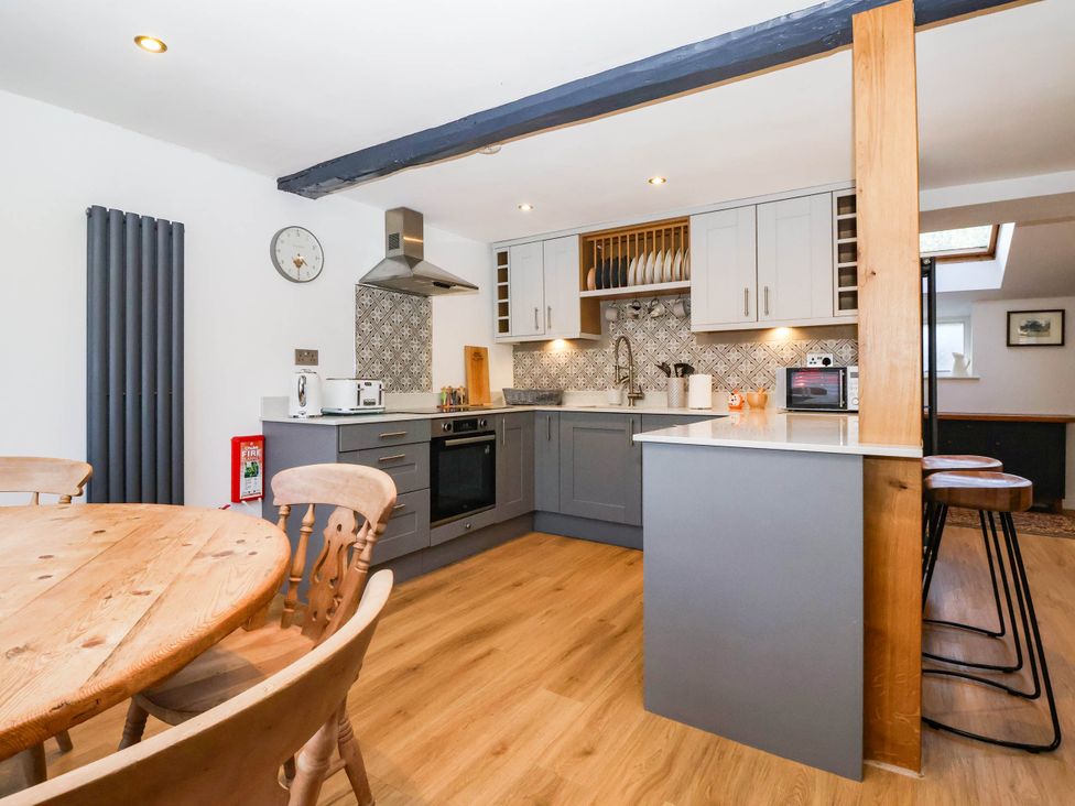 A kitchen with a table and chairs at Winksey Cottage in Harrogate