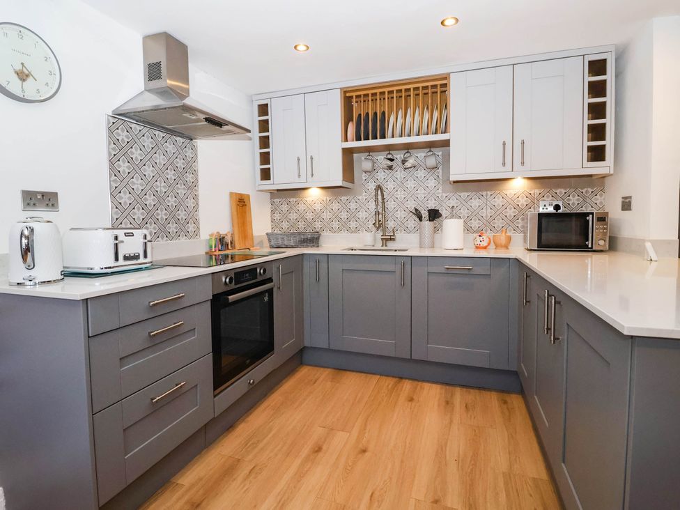 A kitchen with appliances and cabinets at Winksey Cottage in Harrogate