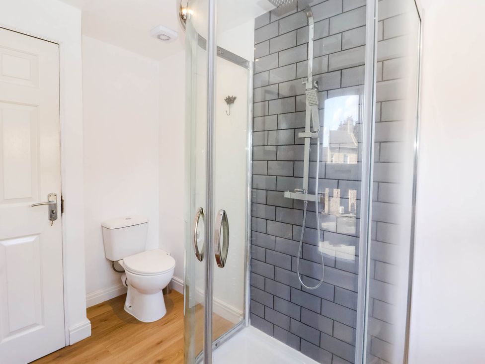 A bathroom with shower and toilet at Winksey Cottage in Harrogate