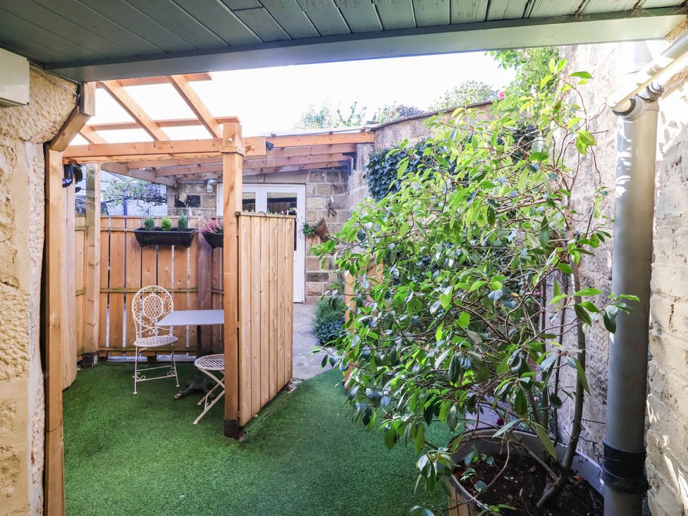 A garden with a table and chairs at Winksey Cottage in Harrogate