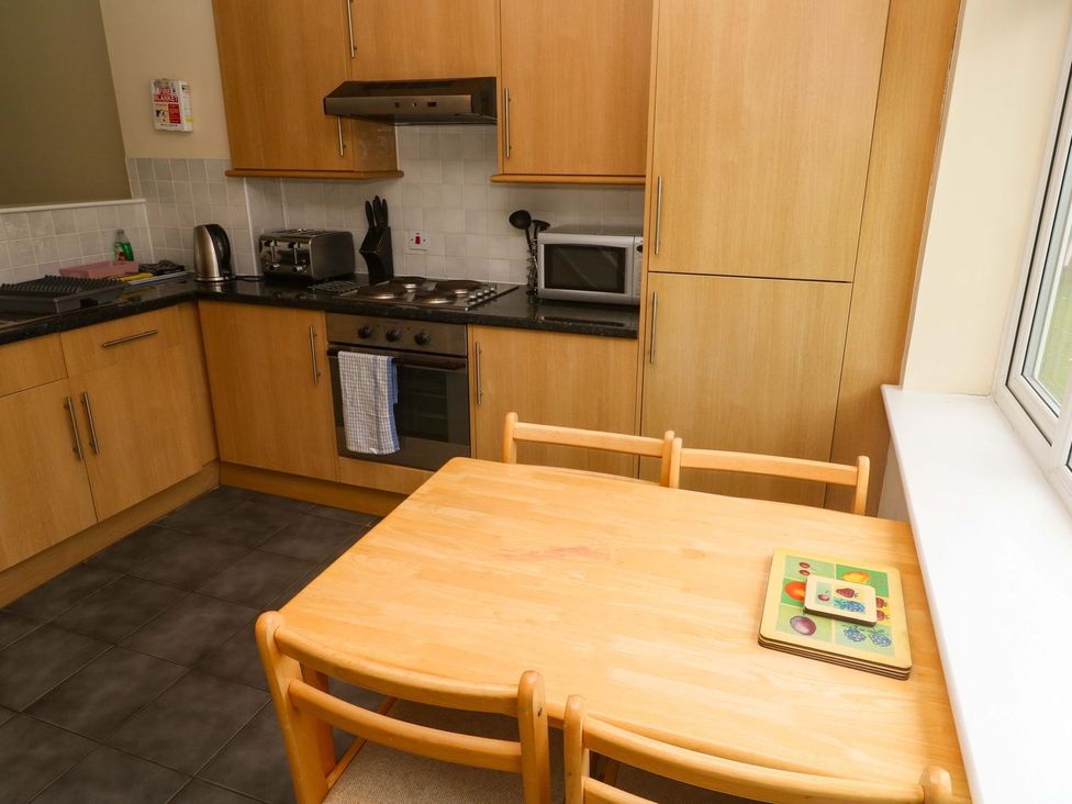 A kitchen with a table and chairs at 87 Atlantic Reach in Newquay