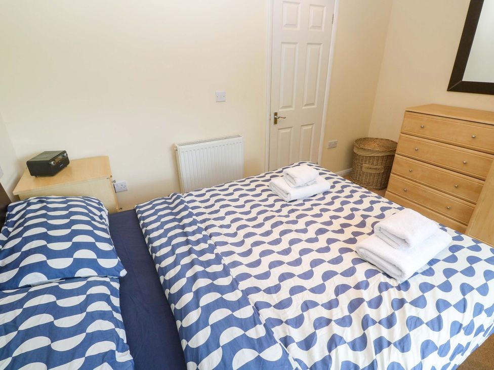 A bedroom with a bed and storage at 87 Atlantic Reach Newquay