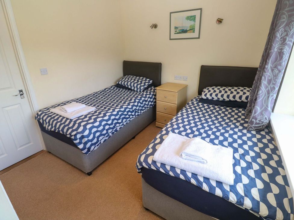 A bedroom with two single beds and a bedside table at 87 Atlantic Reach Newquay
