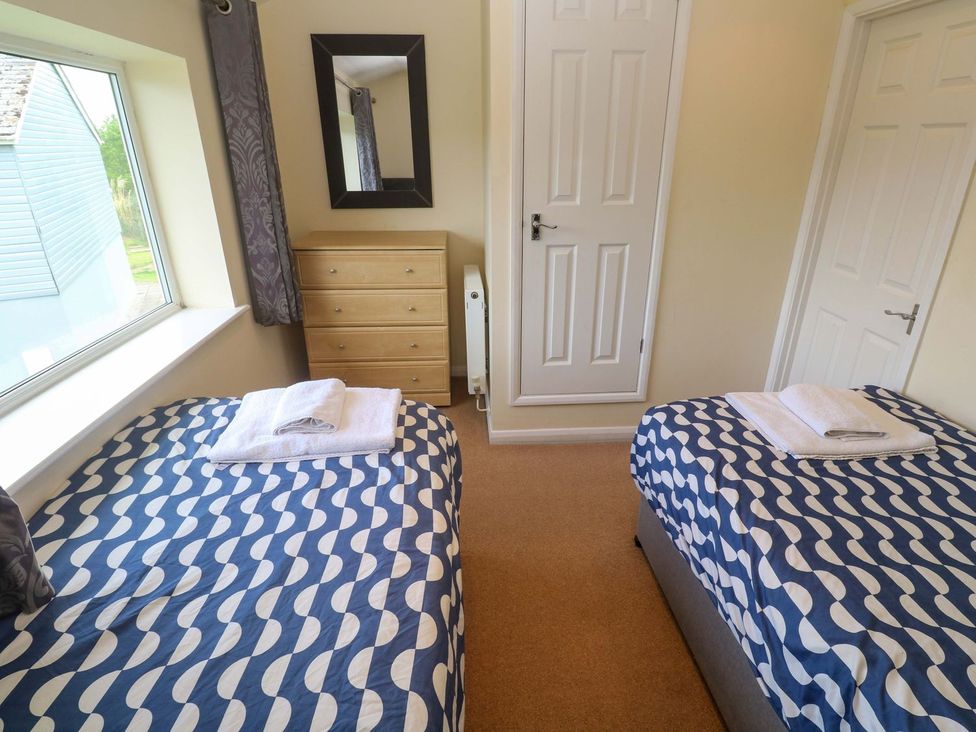 A bedroom with two beds and a dresser at 87 Atlantic Reach in Newquay
