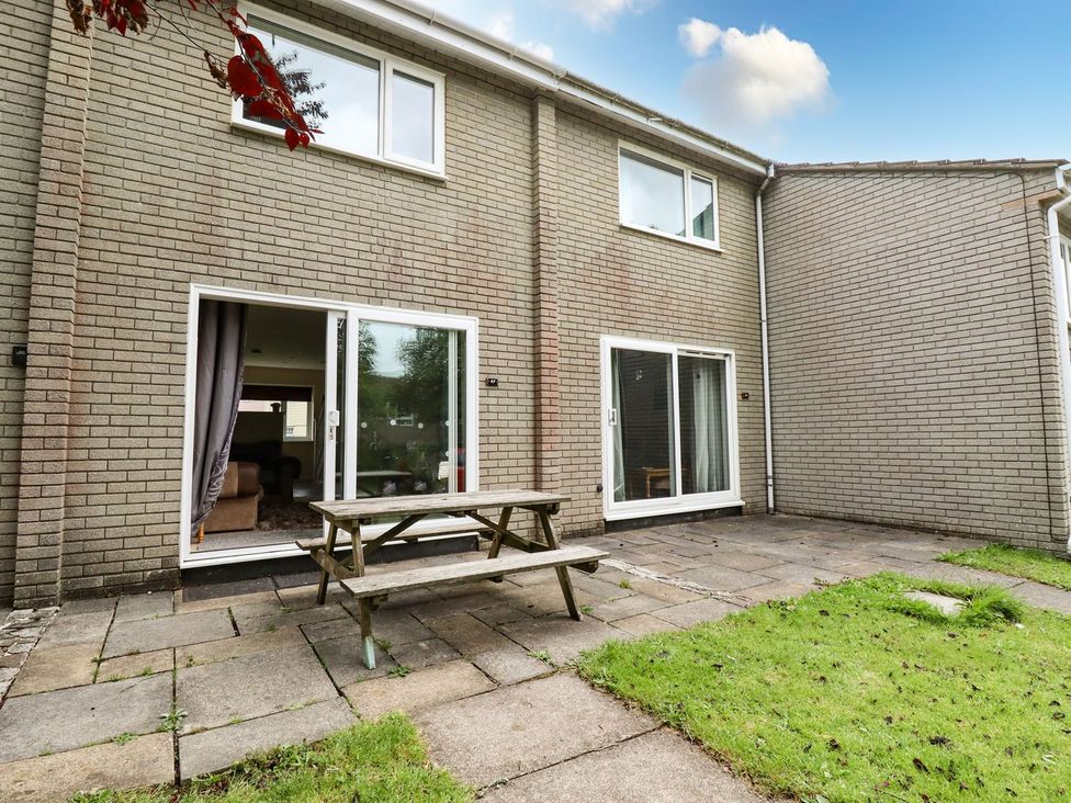 An outdoor area with a table and sliding doors at 87 Atlantic Reach in Newquay
