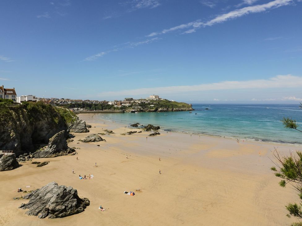 A beach with sand and rocks at 87 Atlantic Reach in Newquay