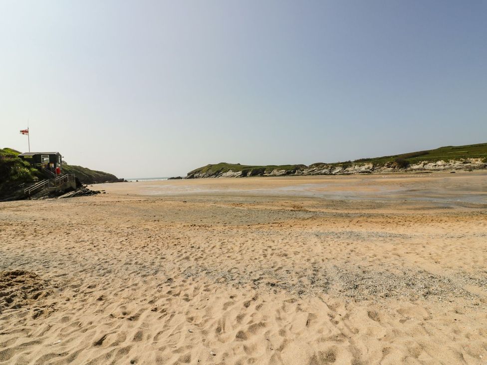 A beach with a lifeguard station and hills at 87 Atlantic Reach Newquay