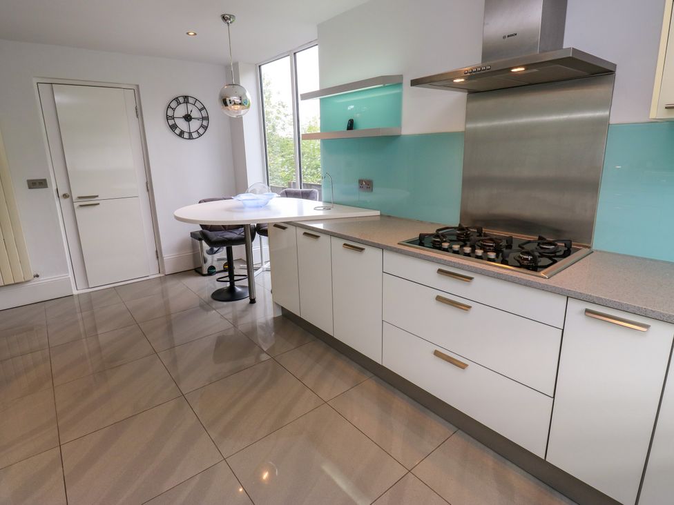 A kitchen with a gas stove and dining table at Nabwood views
