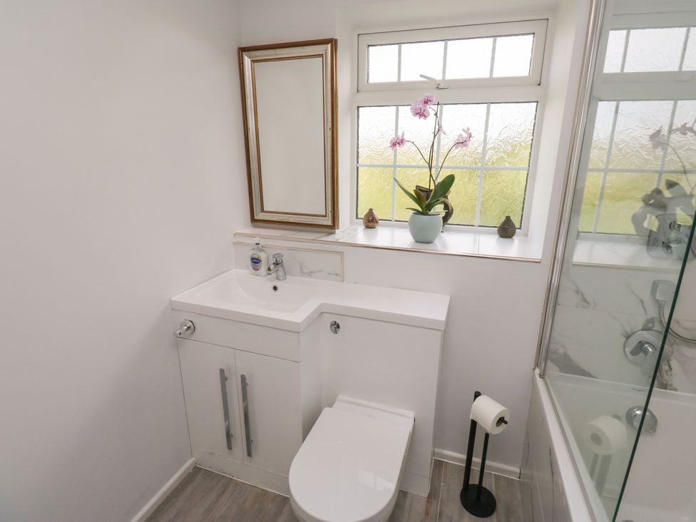 A bathroom with a sink, toilet, and window at Nabwood views in 