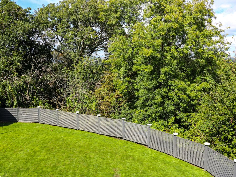A garden with a curved fence and trees at Nabwood views