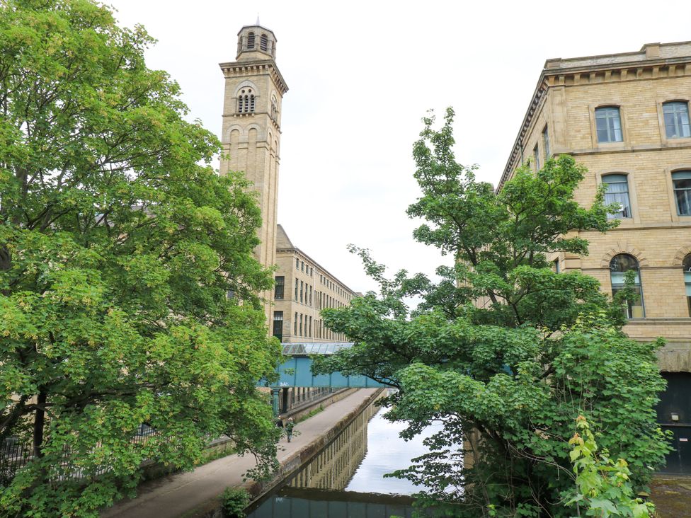 A building with clock tower next to a canal surrounded by trees at Nabwood views