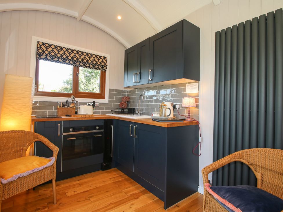 A kitchen with cabinets and appliances at Hideaway Hut at Hopton Court Estate near Cleobury Mortimer