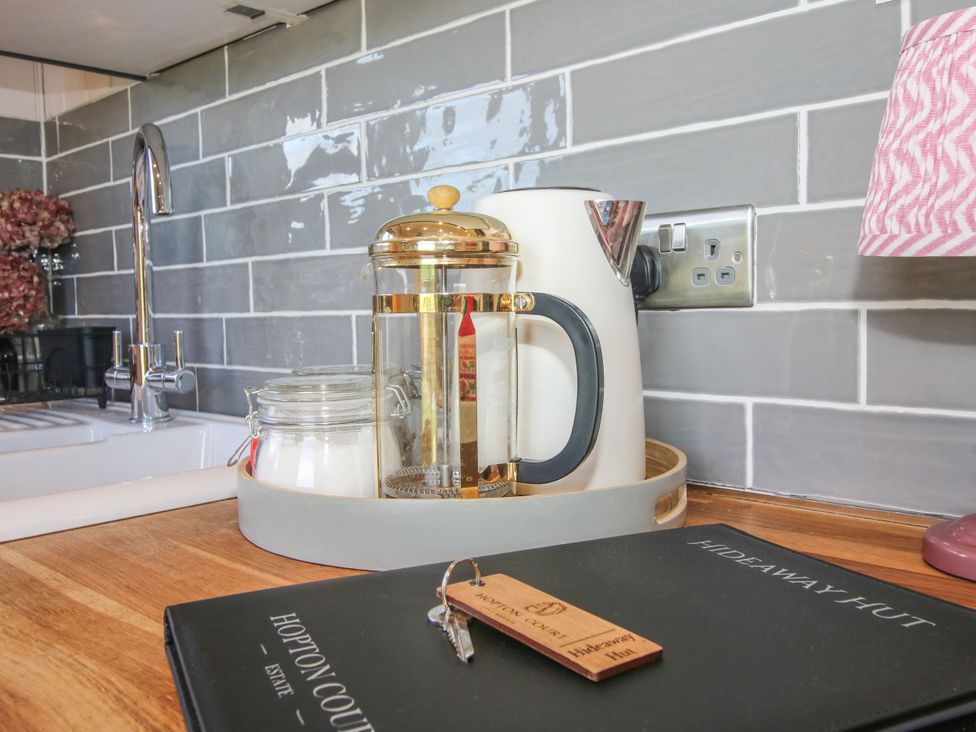 A kitchen countertop with a kettle and French press at Hideaway Hut at Hopton Court Estate