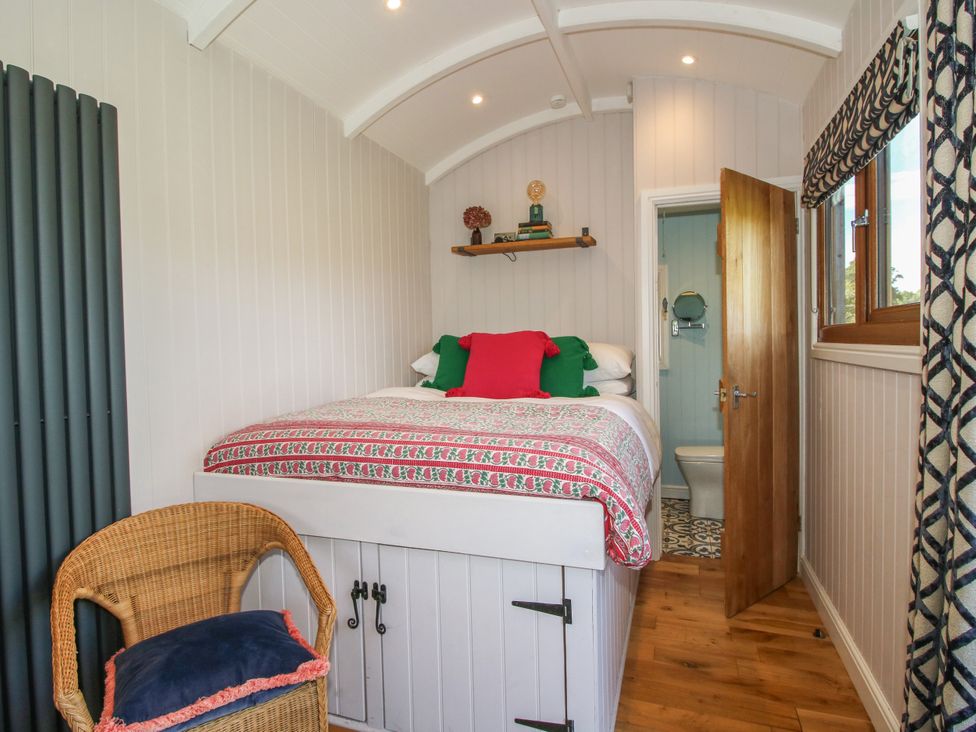 A bedroom with a bed and shelf at Hideaway Hut at Hopton Court Estate Hopton Wafers near Cleobury Mortimer