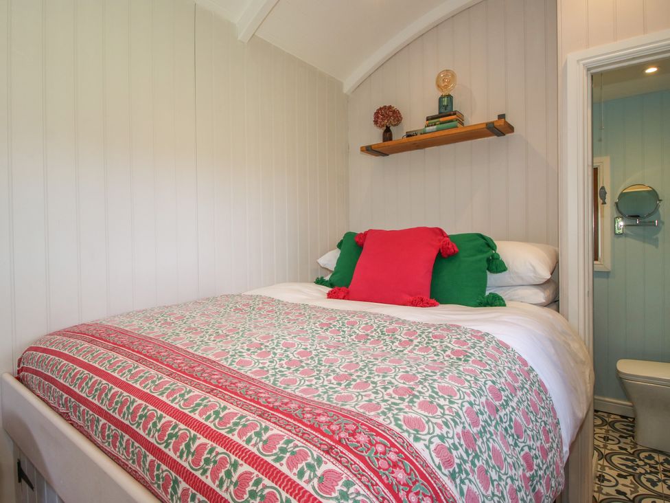 A bedroom with a bed and shelf at Hideaway Hut at Hopton Court Estate near Cleobury Mortimer