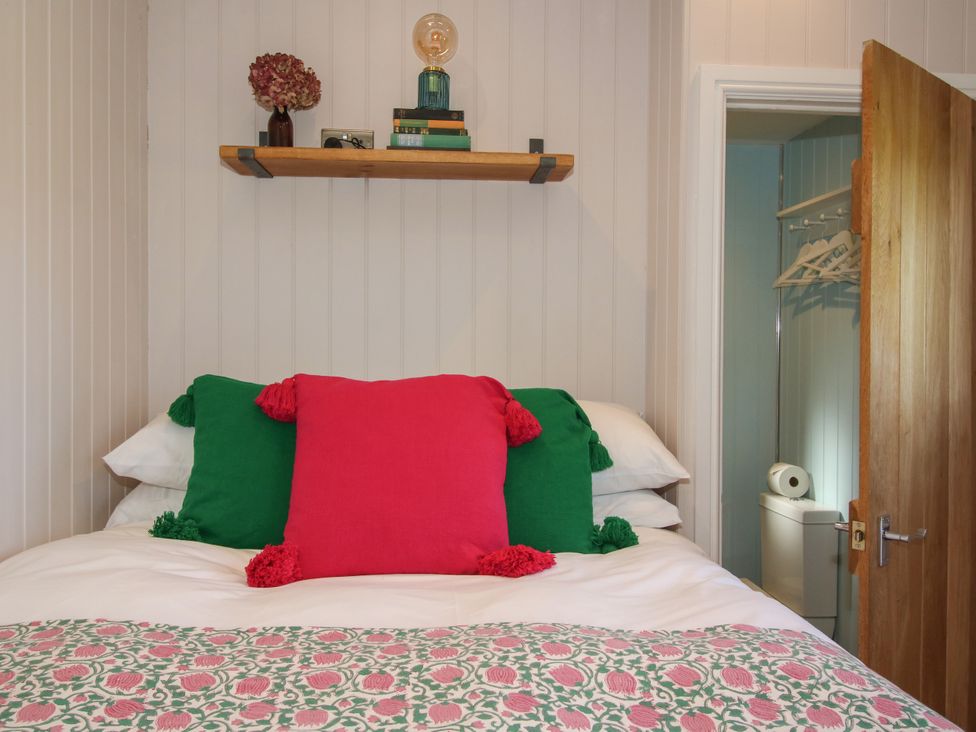 A bedroom with a bed and shelf at Hideaway Hut at Hopton Court Estate near Cleobury Mortimer