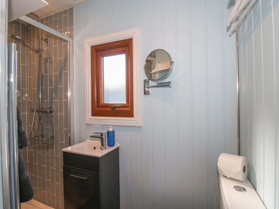 A bathroom with a shower and wash basin at Hideaway Hut at Hopton Court Estate near Cleobury Mortimer