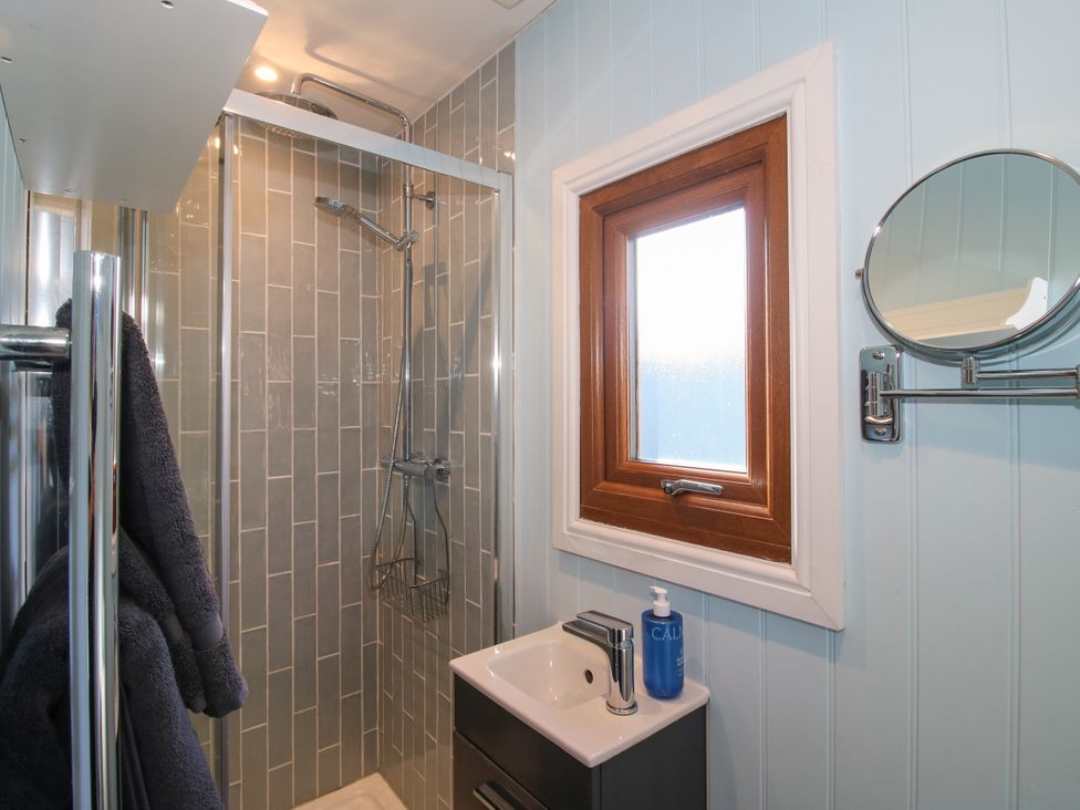 A bathroom with a shower and sink at Hideaway Hut at Hopton Court Estate near Cleobury Mortimer