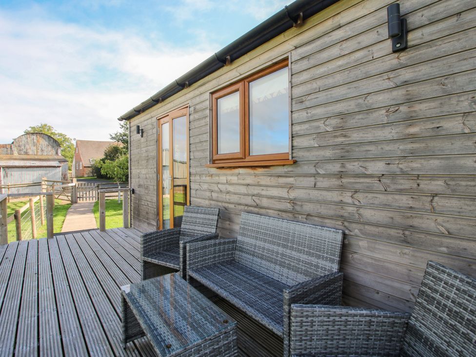 Outdoor seating area with table and chairs at Hideaway Hut at Hopton Court Estate near Cleobury Mortimer