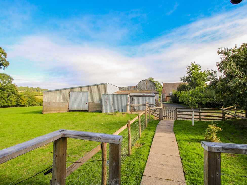 An outdoor area with barns and a path at Hideaway Hut at Hopton Court Estate Hopton Wafers near Cleobury Mortimer
