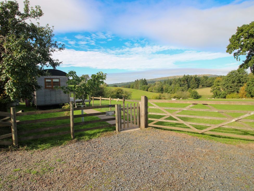An outdoor area with a gate and mobile home at Hideaway Hut at Hopton Court Estate Hopton Wafers near Cleobury Mortimer