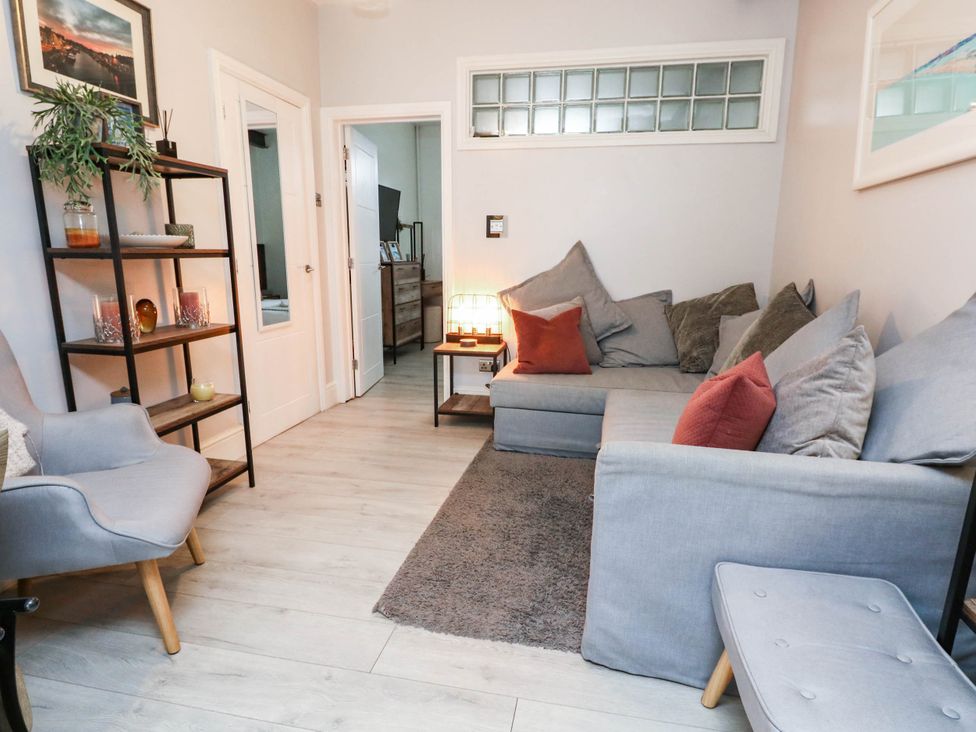 A living room with sofa and bookshelf at Flat 1, 2 Wooperton Street Weymouth