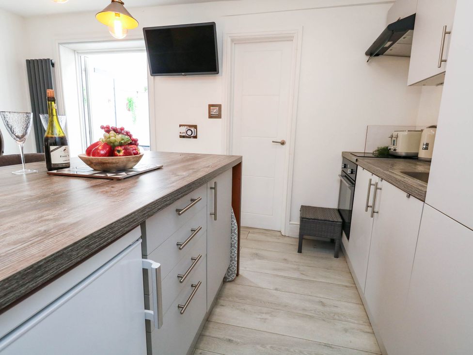 A kitchen with a fruit bowl and bottle of wine at Flat 1, 2 Wooperton Street in Weymouth