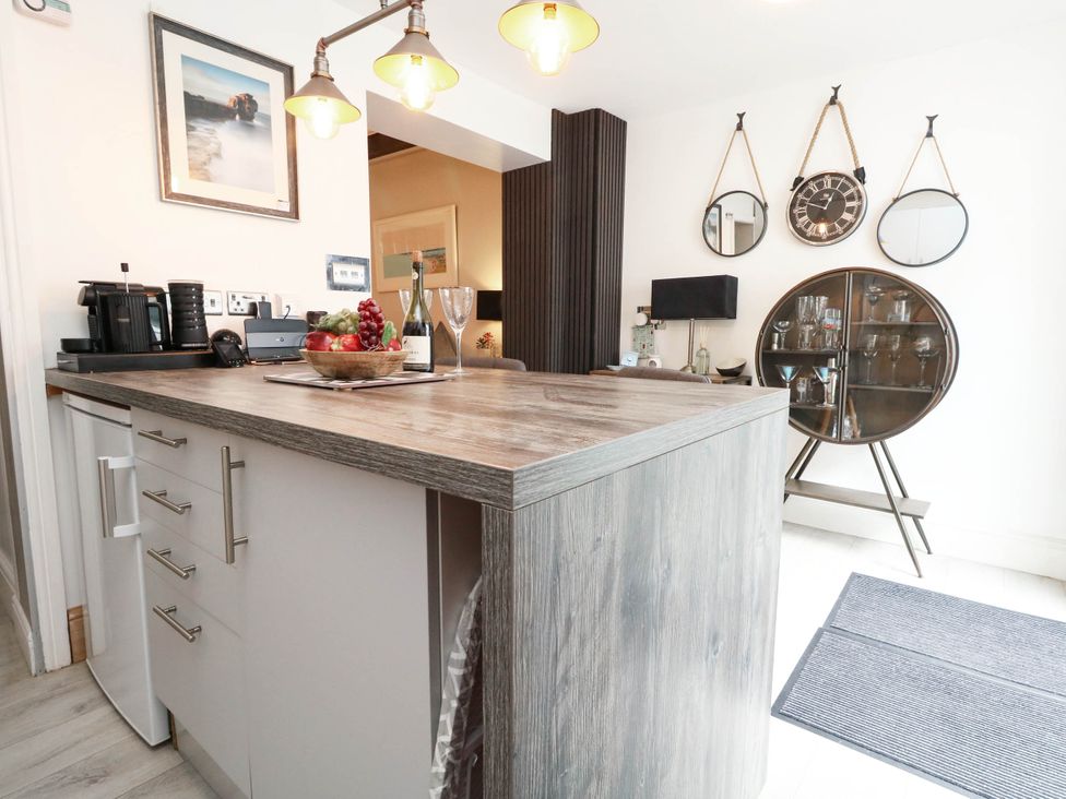 A kitchen with an island, appliance, and decorative wall features at Flat 1, 2 Wooperton Street Weymouth