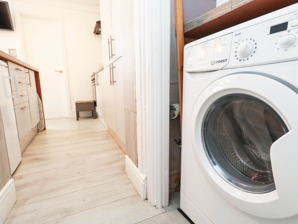A kitchen with a washing machine and cabinets at Flat 1, 2 Wooperton Street Weymouth