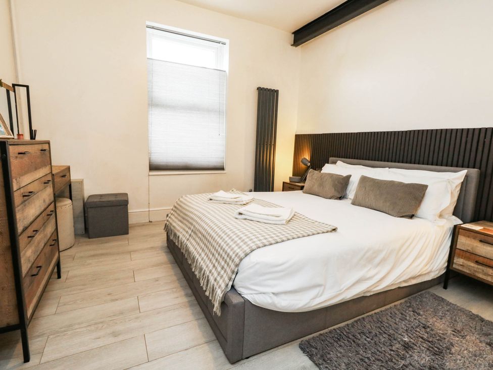 A bedroom with a bed and dresser at Flat 1, 2 Wooperton Street Weymouth