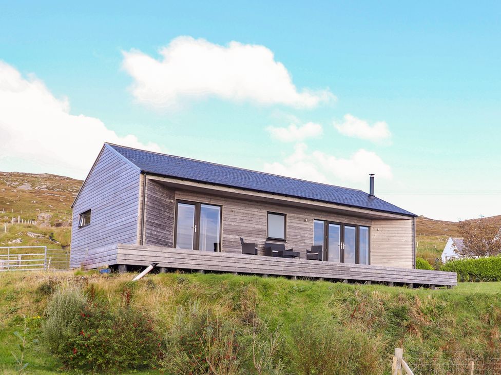 A house with a deck and windows at Holm in Strond near Carminish, Isle Of Harris