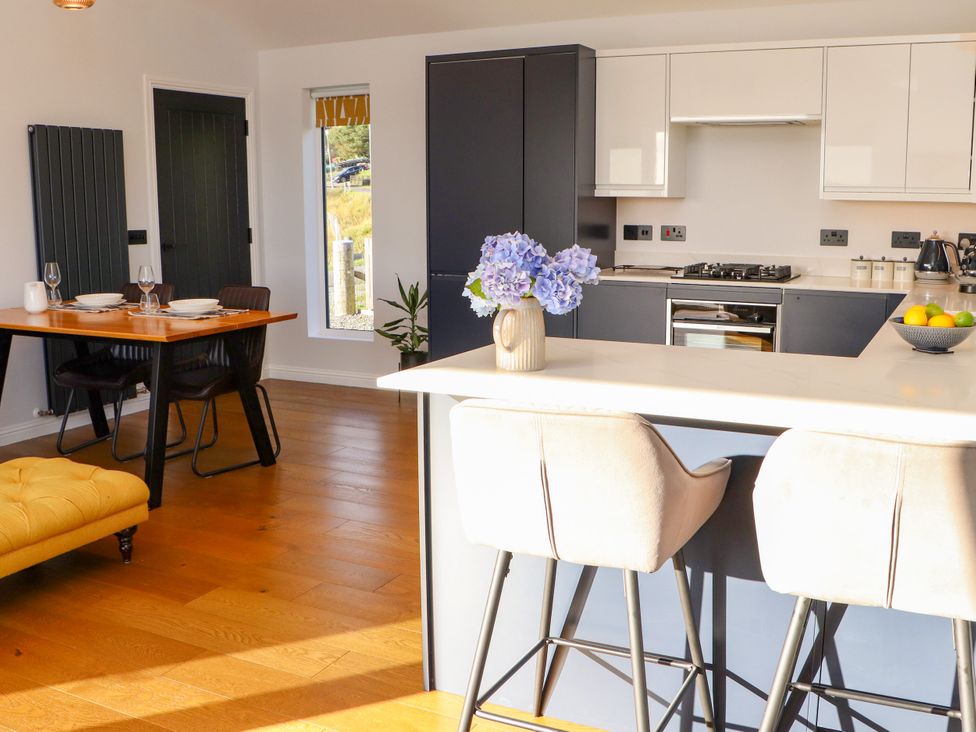 A kitchen with dining area and bar stools at Holm in Strond near Carminish, Isle Of Harris