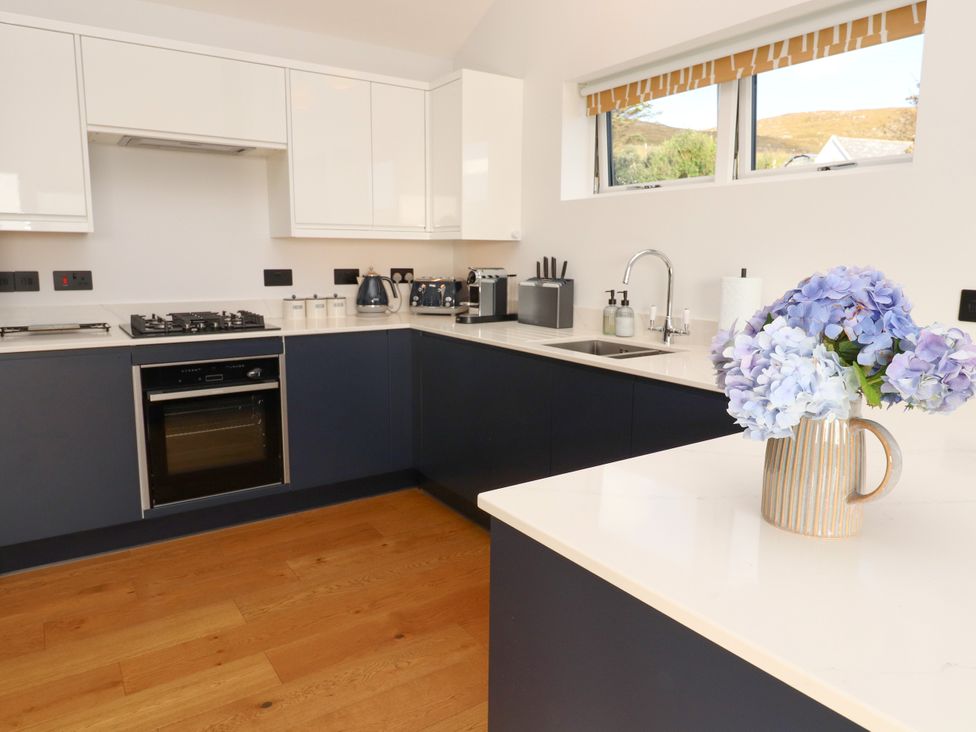 A kitchen with modern appliances and flowers at Holm Strond near Carminish, Isle Of Harris