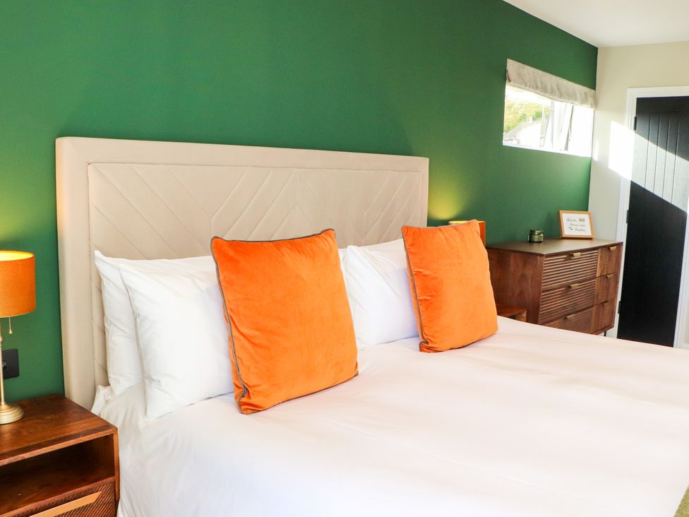 A bedroom with a bed and orange pillows at Holm in Strond near Carminish, Isle Of Harris