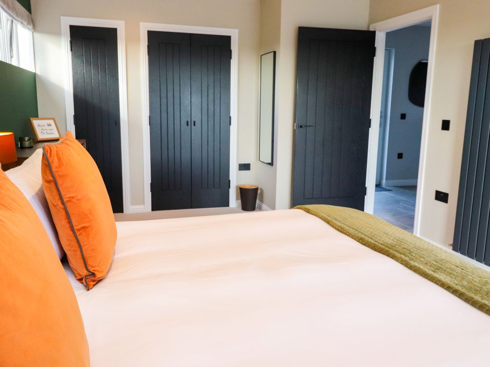 A bedroom with a bed and closet doors at Holm in Strond near Carminish, Isle Of Harris
