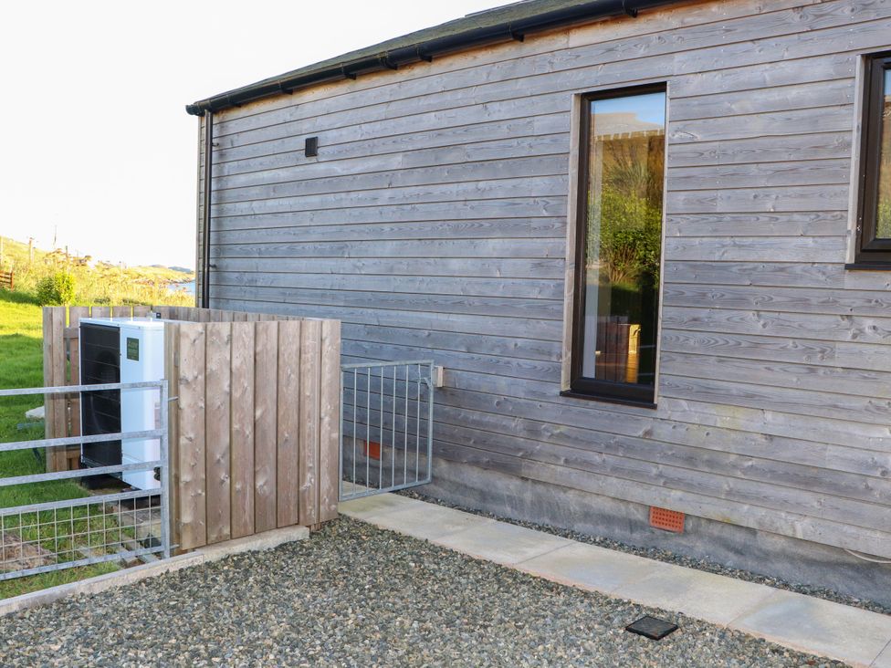 An outdoor view of a house side with air conditioning unit at Holm, Strond near Carminish, Isle Of Harris