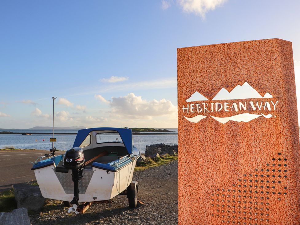 A boat beside a sign on the Hebridean Way near the water