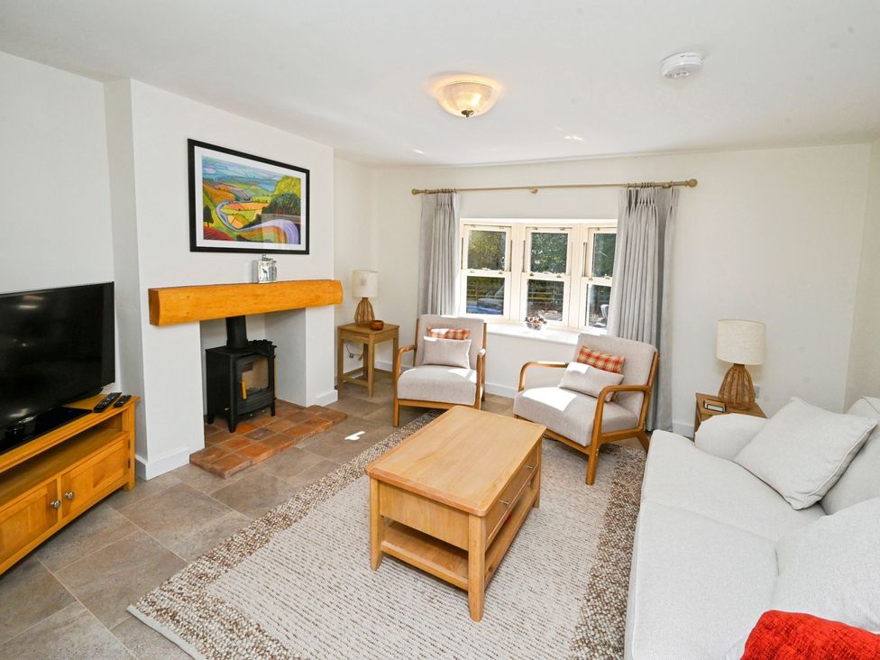 A living room with a television and wood stove at Susans Cottage