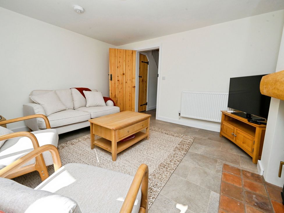 A living room with a sofa and television at Susans Cottage