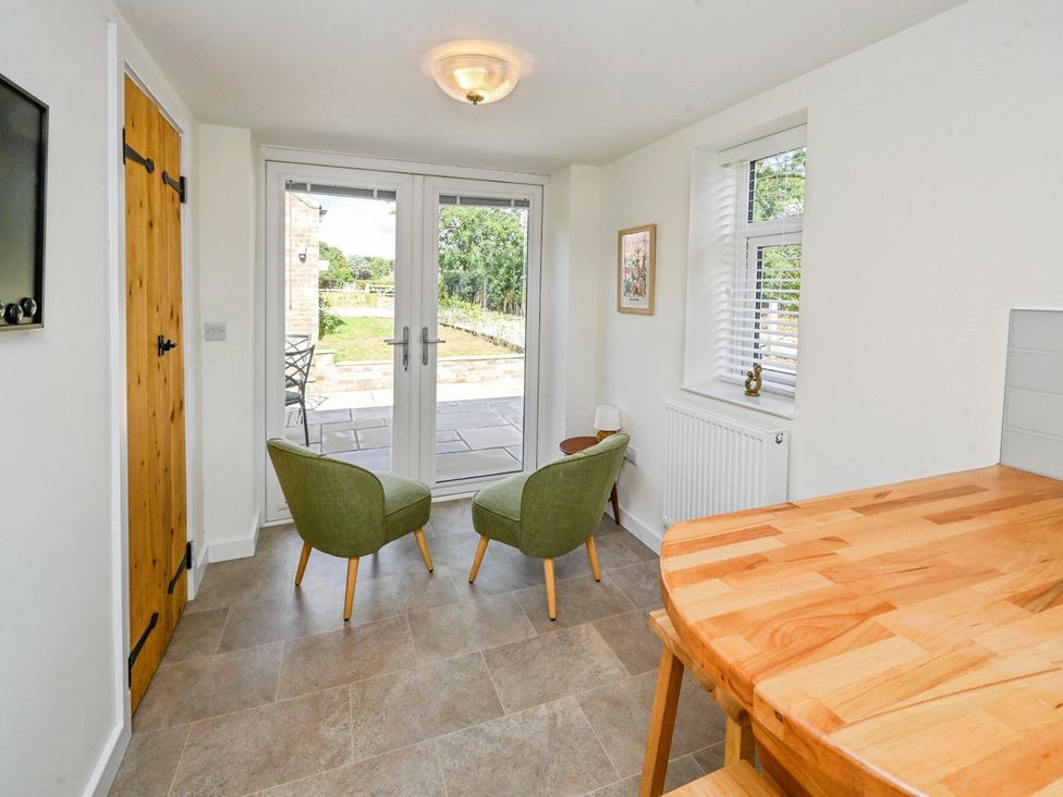 A seating area with two armchairs and a table at Susans Cottage