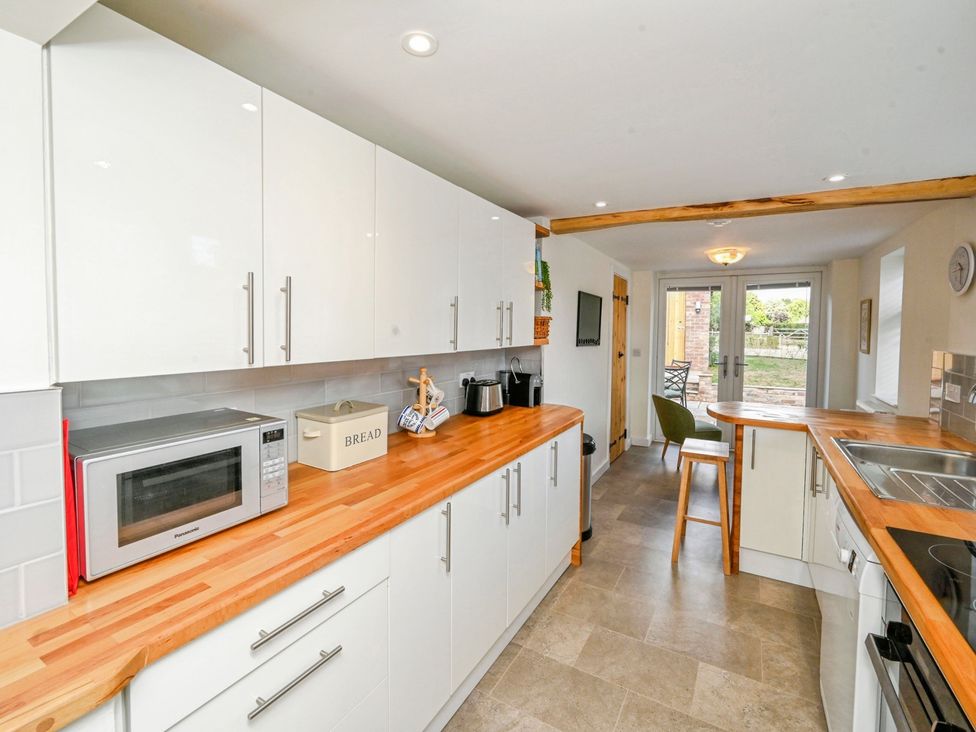 A kitchen with cabinets and appliances at Susans Cottage