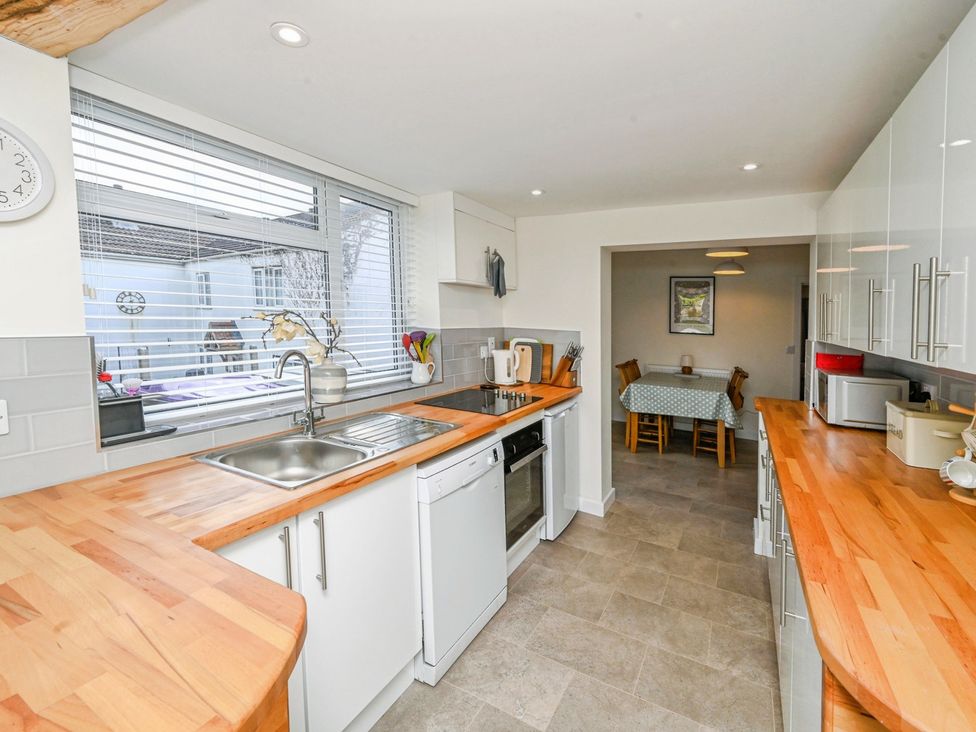 A kitchen with appliances and a dining area at Susans Cottage