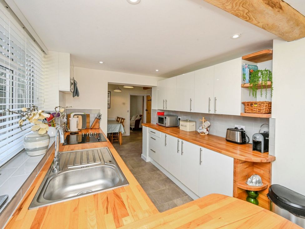 A kitchen with cabinets, appliances, and a sink at Susans Cottage