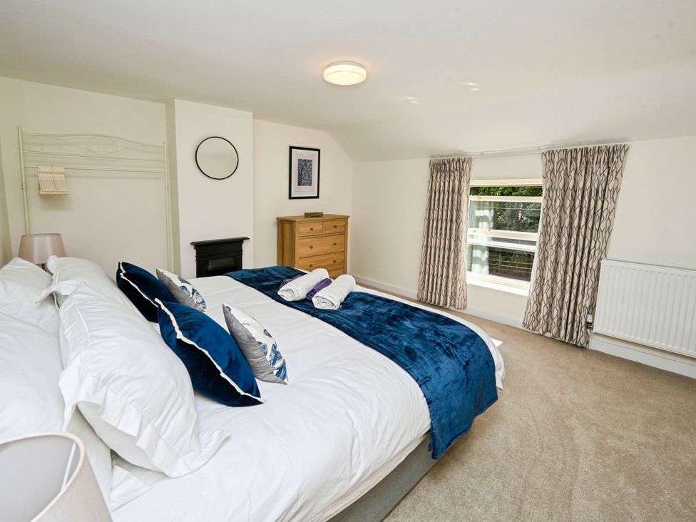 A bedroom with a bed and dresser at Susans Cottage