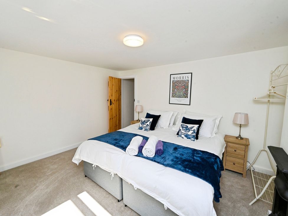 A bedroom with a bed and nightstand at Susans Cottage
