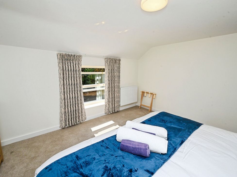 A bedroom with a bed and towels on it at Susans Cottage