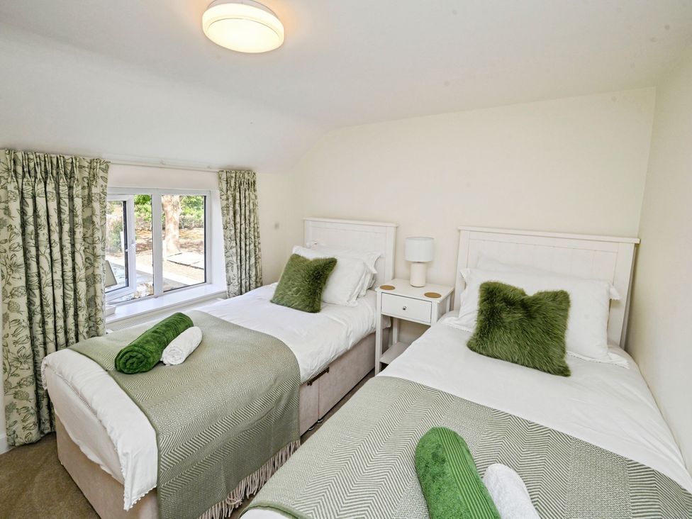 A bedroom with two beds and a window at Susans Cottage