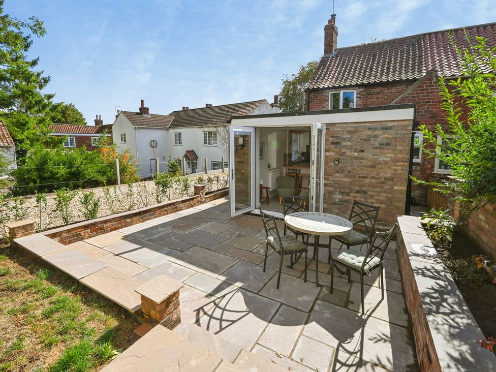 A garden with a patio and seating at Susans Cottage