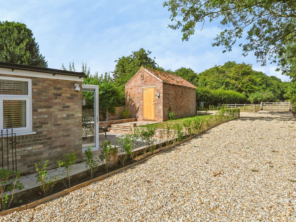 A garden with a house and gravel pathway at Susans Cottage 