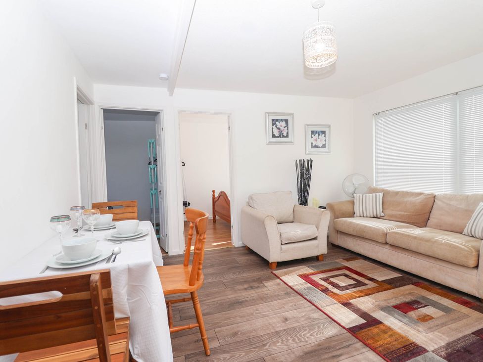 A living room with a dining table and wooden chairs at 122 Norton Park Dartmouth